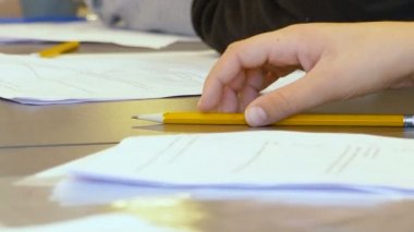Küçük İsrailli beyaz yetenekli çocuk bir ilkokul sınıfında sınava giriyor. Sınavı çözmeye ve cevaplarını kağıda yazmaya çalışıyor. Yakın çekim elinde bir kalemle oynuyor..