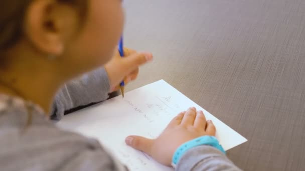 在小学班级的笔记本上写着一个有才华的以色列小女生 她试图解决这个问题 并把答案写在纸上 Ots靠在她的手上和铅笔上 — 图库视频影像