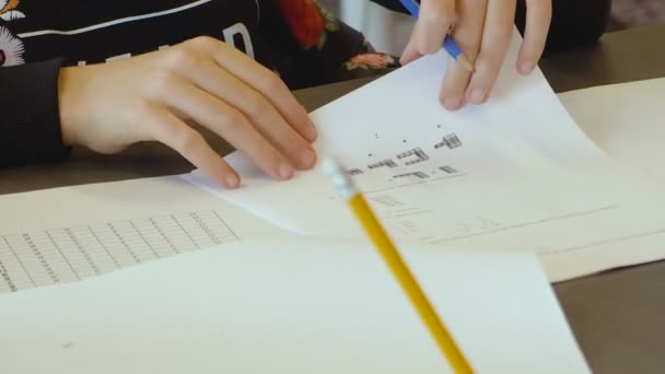 以色列白人小女孩 天分很高 在小学的课堂上参加考试 她试图解题 并把答案写在纸上 Ots紧紧抓住她的手和笔 — 图库视频影像