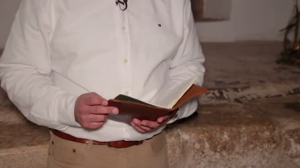 在阅读一本旧书或日记的时候 走近一个人 一个无法辨认的人手里拿着这本书 — 图库视频影像