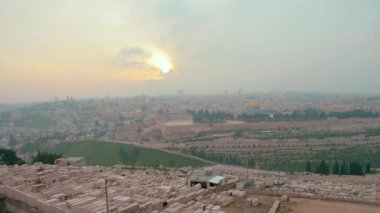 Kudüs 'ün eski şehri ve Tapınak Dağı' nın dramatik renkli günbatımında panoramik manzarası. Kehanetler Mezarlığı, Kaya Kubbesi ve İsrail 'in Kudüs kentindeki Zeytin Dağı' ndaki El Aksa Camii 'nin manzarası..