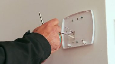 Teknisyen akıllı bir ev güvenlik sisteminin alarmını kuruyor ya da onarıyor. Hırsızlığı önlemek için kapı sensörü. Elindeki alçak açıyı kapat..