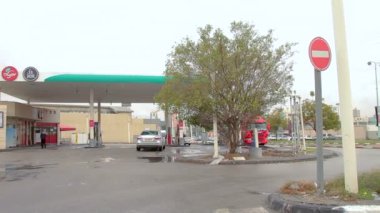 Birüssebi, İsrail - 13 Aralık 2018: Özel araba kış günü Birüssebi 'de bir benzin istasyonuna girer. Çatıda kırmızı bir 'Delek' benzin istasyonu, 'Menta' market ve 'Joe' kahve tabelaları var..