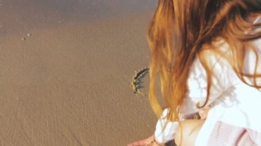 Kaygısız, tanınmayan bir kız gün batımında ıslak kumun üzerine kalp şekli çiziyor. İsrail, Tel Aviv 'de altın gündoğumunda ferahlatıcı bir denize sahip tropikal bir sahil..