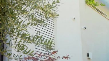 Pencereye açılan elektrikli bir deklanşörün sineması. Açık havada akıllı ev kameraları sistemi. Geniş açı ve alçak açı..