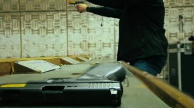 Tanımlanamayan iki adamın 9 mm 'lik tabancayla atış yaptığı bir görüntü. Ön plandaki silaha yaklaş. Döngü, seçici odak ve kopyalama alanı.