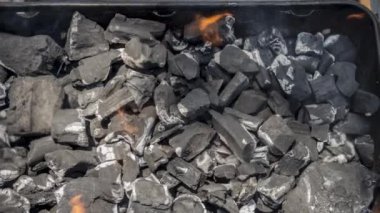 Barbekü ızgarasında yanan kömürün sineması. Üst görünümü kapat, seçici odak ile döndür.