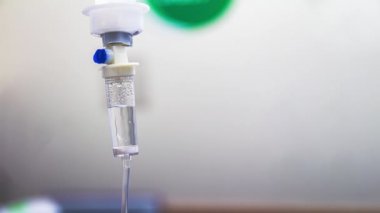 Hastane odasında damardan akan sıvı salin damlalarının sinemagrafı. Beyaz arka planda damardan serum damlası tuzuna yaklaş. Döngü, seçici odak ve boşluğu kopyala.