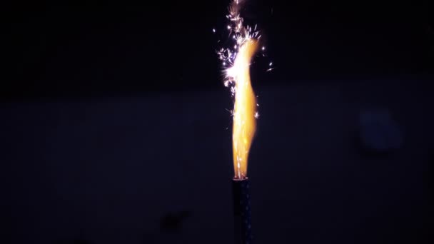 在黑暗中 火花在烟火蜡烛上爆炸的电影图 靠近燃烧的烈焰 带有选择性焦点的循环 — 图库视频影像