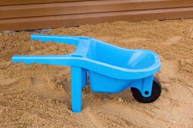 Mavi çocuk oyuncak el arabası kum üzerinde