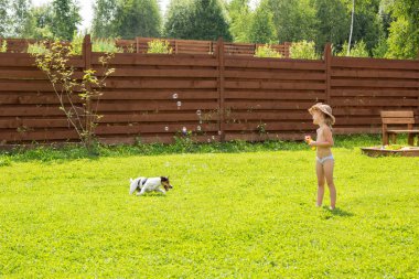 küçük kız köpek ile sabun kabarcıklar oynuyor