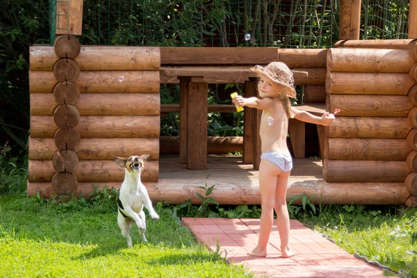 küçük kız köpek ile sabun kabarcıklar oynuyor