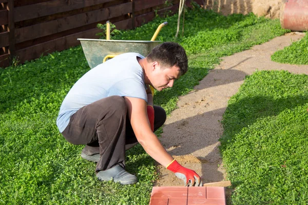 Man puts concrete tiles on the path — Stock Image Man puts concrete tiles on the path Stock Photo