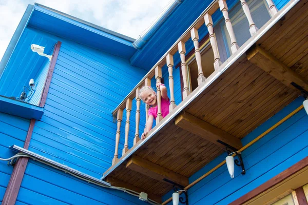 Meisje op zoek naar beneden vanaf balkon — Stockfoto
