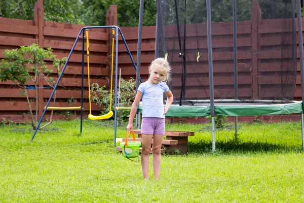 Meisje met emmer water gaat wassen haar trampoline — Stockfoto