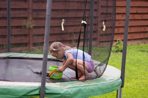 Meisje wast haar trampoline in achtertuin — Stockfoto