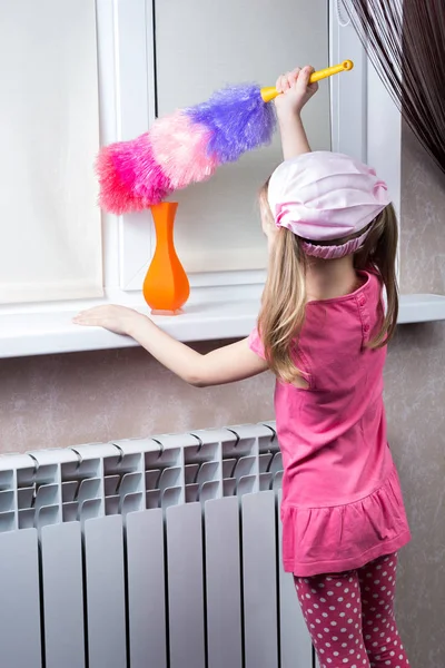 Маленькая девочка вытирает пыль кисточкой — стоковое фото