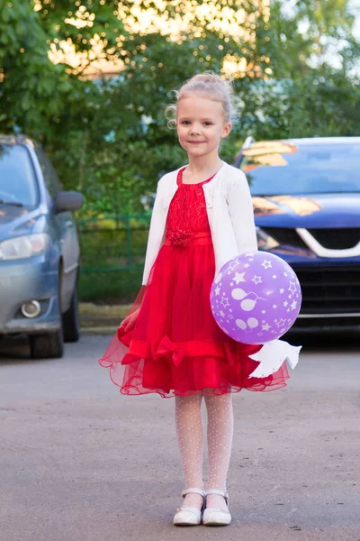 Menina bonito em vestido vermelho com um balão — Fotografia de Stock