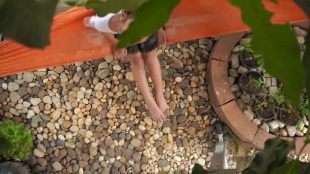庭のハンモックに座って子供たち — ストック動画