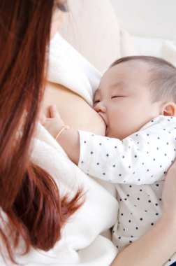 Anne sütü bebeğine bir Asyalı kadın