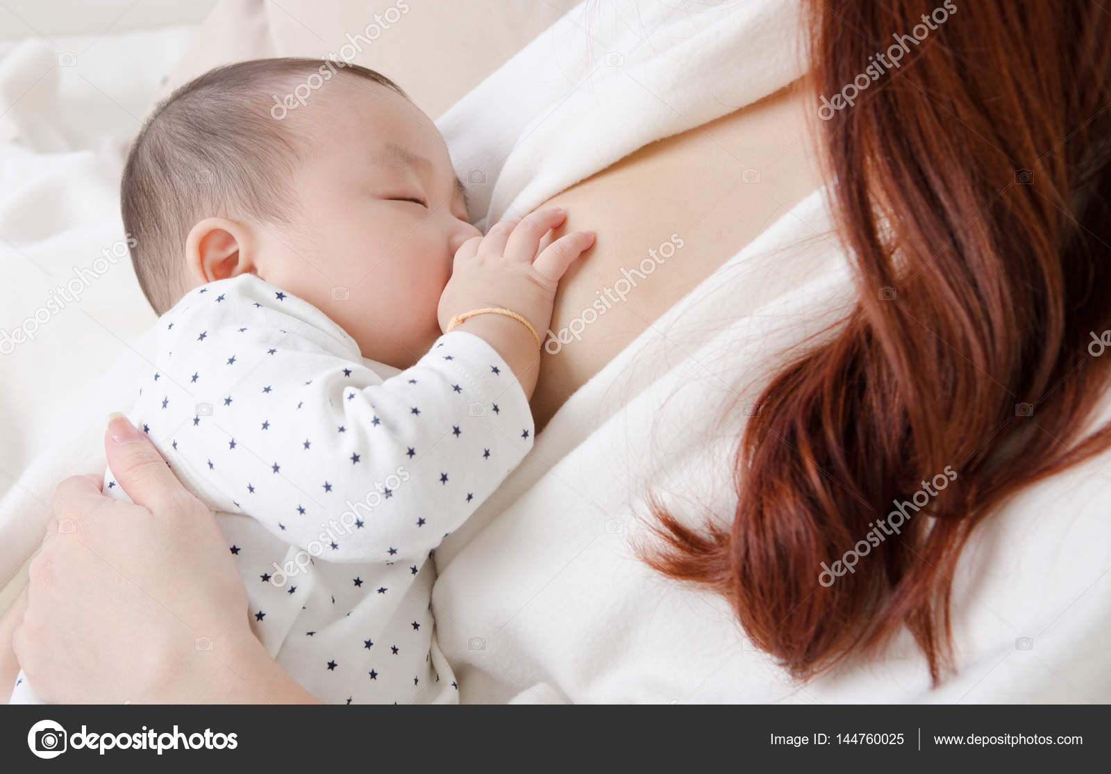 Asian woman giving breastmilk to her baby — Stock Photo © szeyuen