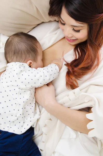 Mulher asiática dando leite materno para seu bebê — Fotografia de Stock