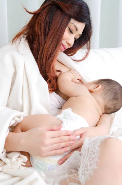 Asian woman giving breastmilk to her baby — Stock Photo, Image