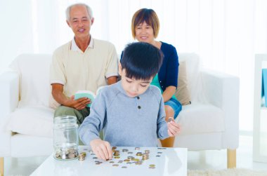 Madeni para sayma onların torunu Asya kıdemli çift. Para tasarrufu kavramı.