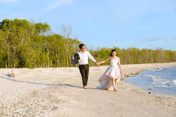 Asiatisch Braut Und Bräutigam Walking Die Strand lizenzfreie Stockbilder