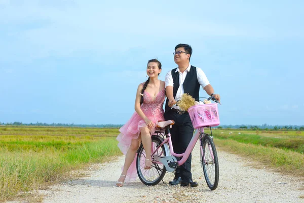 自転車の水田を見るアジアの花嫁と新郎 ストック画像