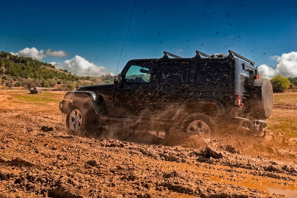 Veículo todo-o-terreno que passa por uma área de lama — Fotografia de Stock