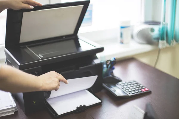 girl in the office prints documents on a printer. girl at work i