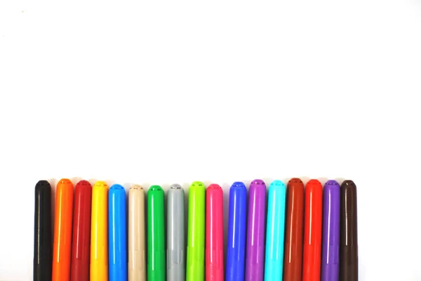 multi-colored felt-tip pens on a white sheet of paper. felt-tip
