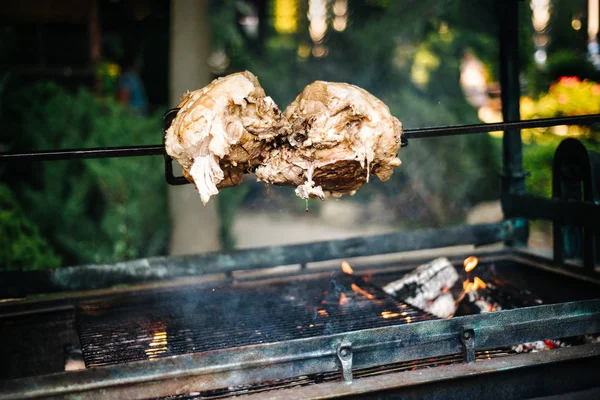 Grande pedaço de porco cozinhando em fogo aberto, chama ao ar livre — Fotografia de Stock