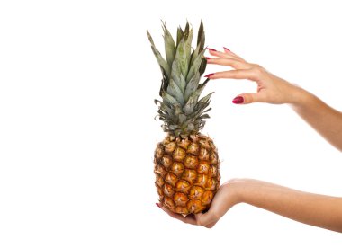 Bir ananas beyaz bir arka plan üzerinde tutan bir kız.