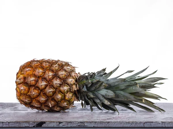 Pineapple is on a wooden table in the studio on a white backgrou — Stock Photo, Image