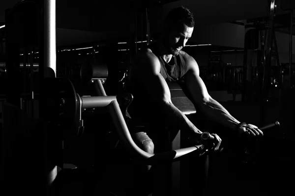 Hombre deportivo haciendo ejercicio con barra en el gimnasio — Foto de Stock