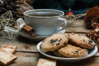 Güzel genel kavram. Çikolata kurabiye ahşap arka plan üzerinde beyaz bir tabakta. Yakın bir Noel ağacı, oyuncak, çay, çelenk ve Noel oyuncaklar standları.