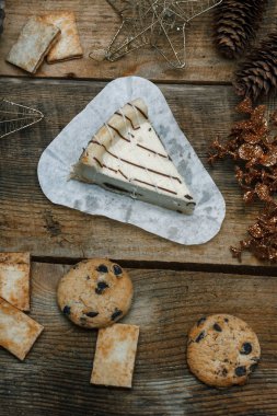 Çikolata kurabiye ahşap arka plan üzerinde beyaz bir tabak içinde. Çevre koniler ve tarçın sopa, kabaca. Yukarıdan görüntüleyin. Yeni yıl tatili Tema