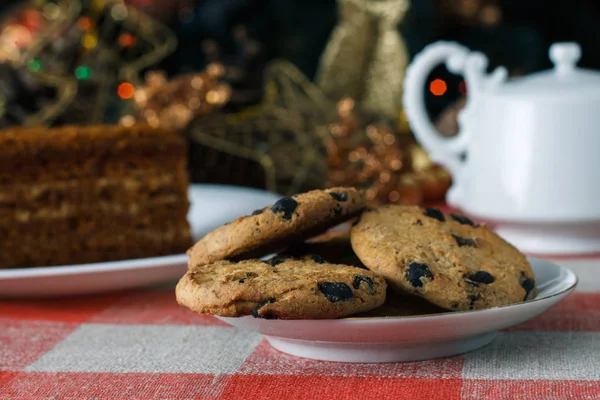 Homemade cookies in a plate on the feast of the new year, christmas. Tasty cookies on a table with a Christmas tree in the background. Tea. — Stock Photo, Image