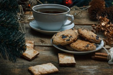 Güzel genel kavram. Çikolata kurabiye ahşap arka plan üzerinde beyaz bir tabakta. Yakın bir Noel ağacı, oyuncak, çay, çelenk ve Noel oyuncaklar standları.