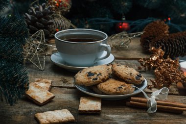 Güzel genel kavram. Çikolata kurabiye ahşap arka plan üzerinde beyaz bir tabakta. Yakın bir Noel ağacı, oyuncak, çay, çelenk ve Noel oyuncaklar standları.