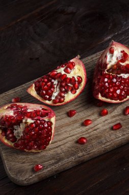 ahşap arka plan üzerinde ahşap bir gemide nar parçası kesmek.