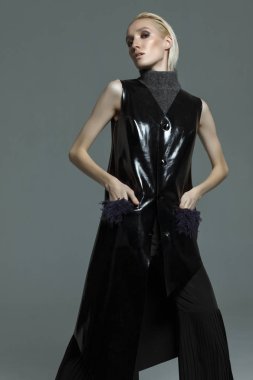 Moda fotoğrafçılığı. Studio gri bir arka plan üzerinde elbise kız siyah Tasarımcısı. Kız sarışın raslablennoy poz. Reklam elbise.