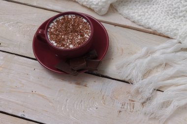 Sütlü çikolata bir fincan bir daire ahşap zemin üzerinde.