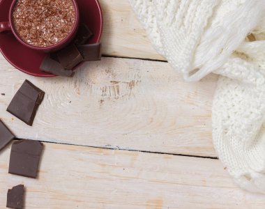 Sütlü çikolata bir fincan hafif ahşap arka plan üzerinde bir daire üzerinde