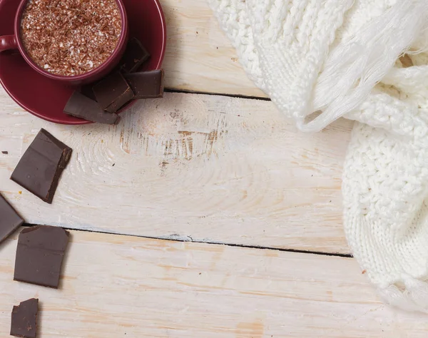 Sütlü çikolata bir fincan hafif ahşap arka plan üzerinde bir daire üzerinde