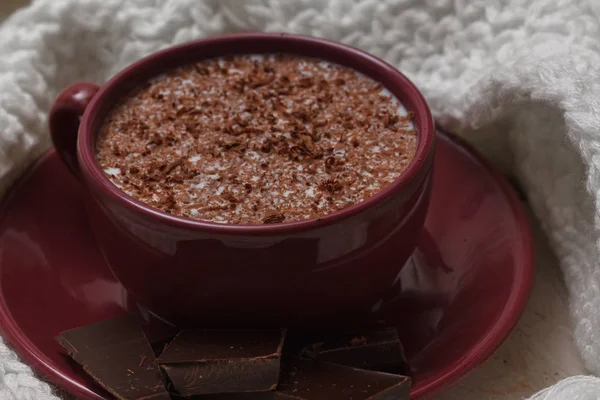 Chocolate de leite em uma xícara em um pires contra um contexto de um sc — Fotografia de Stock