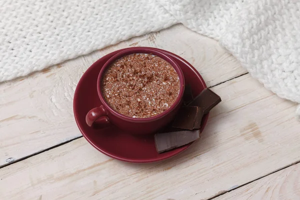 Chocolate de leite em uma xícara em um pires contra um contexto de um sc — Fotografia de Stock