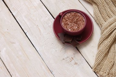 Sütlü çikolata bir fincan hafif ahşap arka plan üzerinde bir daire üzerinde